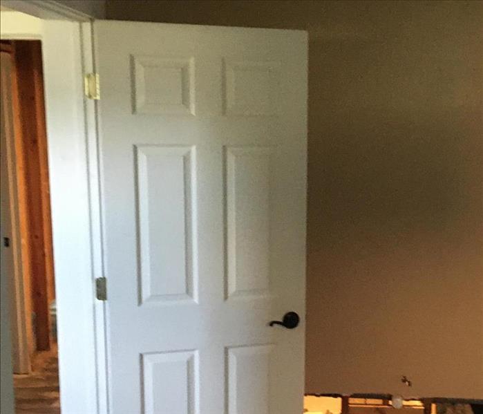 A door is reinstalled after mold mitigation has been completed on it. 
