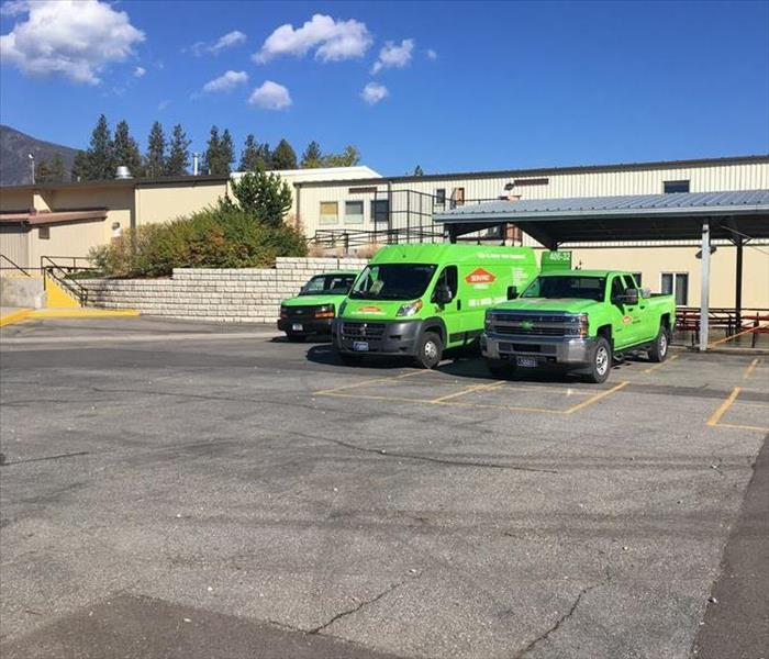 Three of SERVPRO of Missoula's vehicles, which include trucks, mid-size, and large vans. 