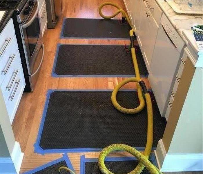 Water extraction mats placed over a hardwood, kitchen floor. 