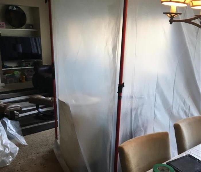 Plastic containment barriers are set up around the center of a dining room where mold was found. 